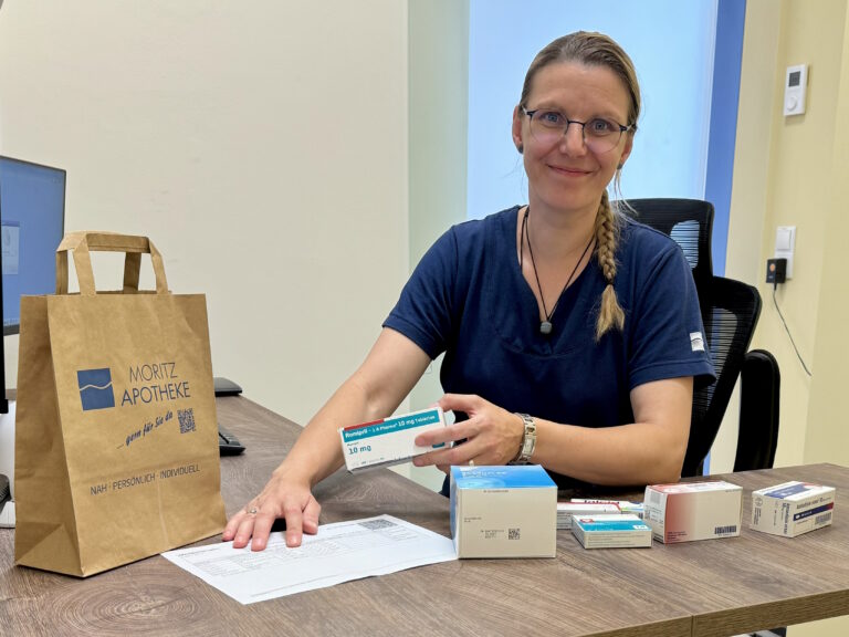 Apothekerin Franziska Bake-Kellner sitzt am Tisch und macht eine Medikationsanalyse in der Moritz Apotheke Limbach-Oberfrohna